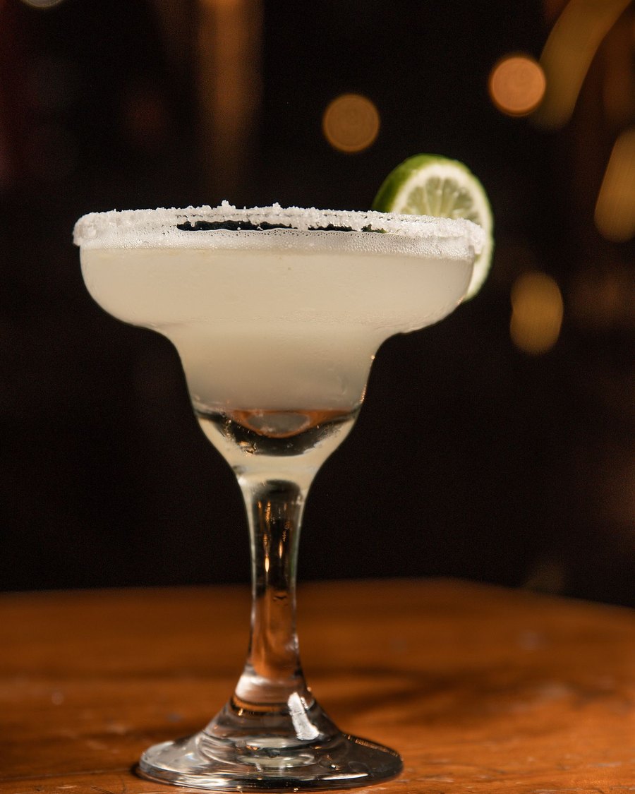 Licensed stock photograph: a margarita with a salted rim and a wedge of lime.